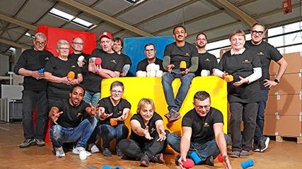 BrandedMics production staff sitting in a warehouse with bright blue foam covers.